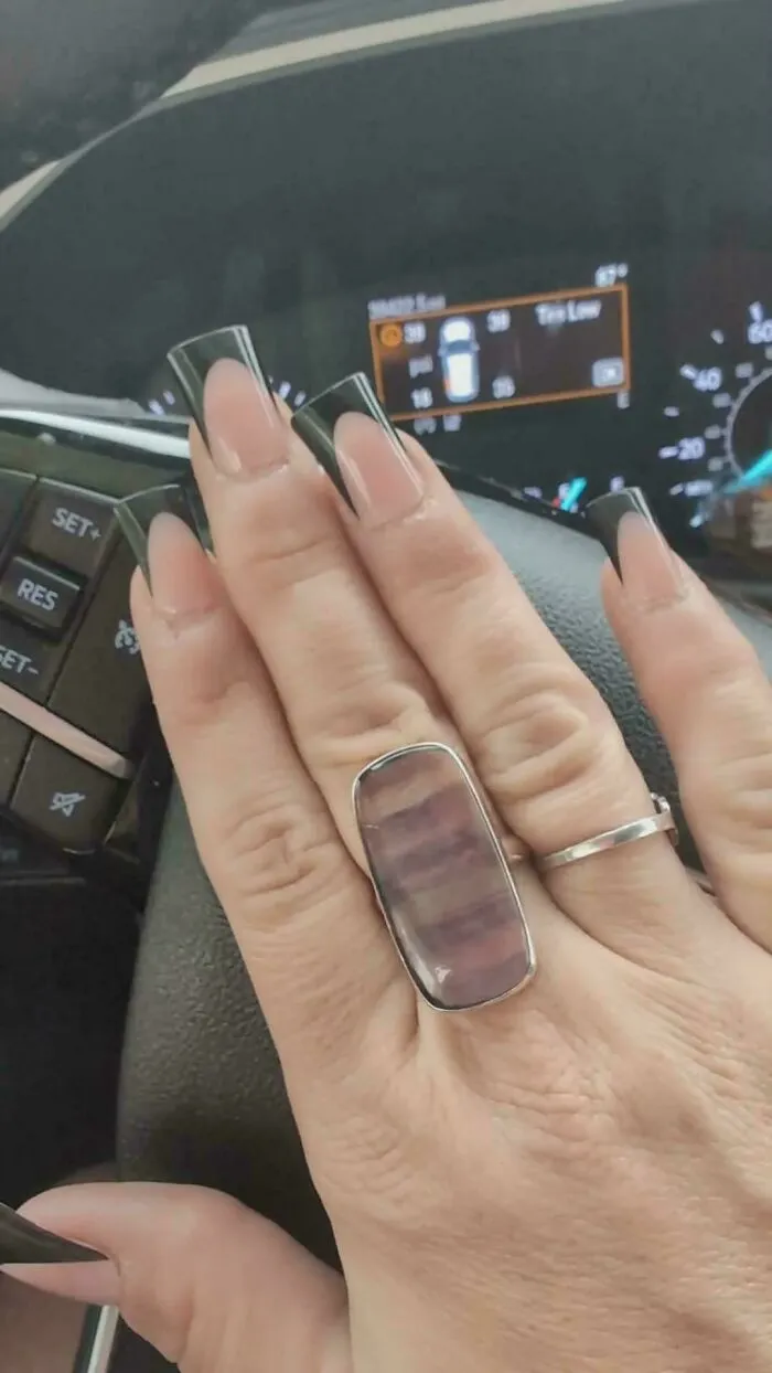 Hand with nails painted to look transparent and a ring resembling a screen