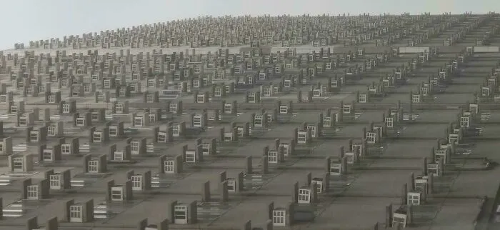 Facade of a tall building with hundreds of identical air conditioning units in a grid