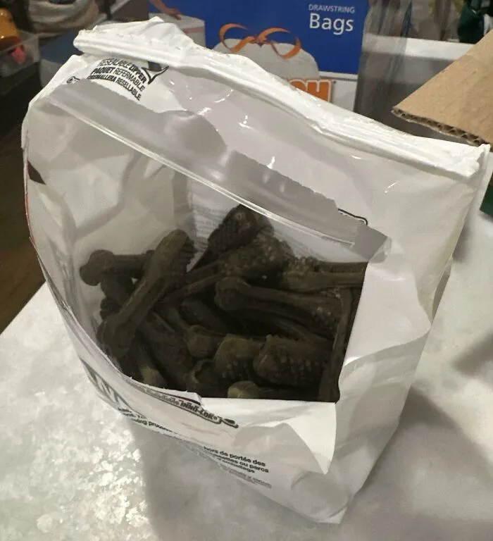 A plastic bag of dog treats clumsily torn open, showing funny things wives do.