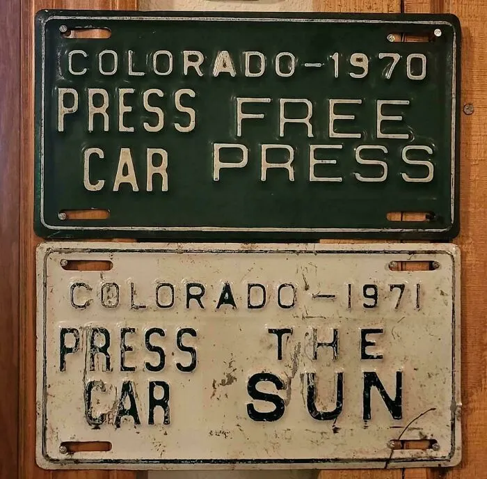 Vintage Colorado license plates with confusing text layout, serving as badly designed signs.