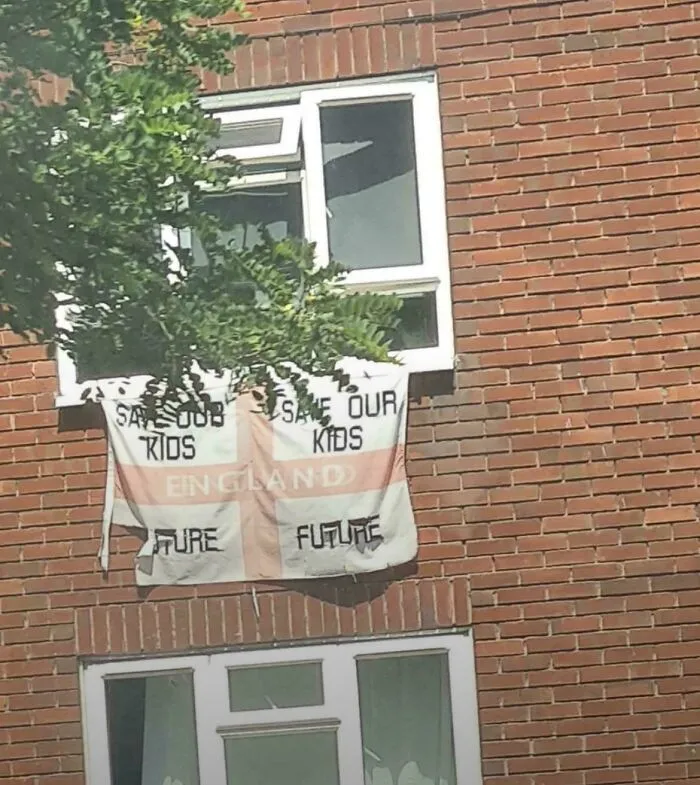 A flag with confusing text hanging outside a window showing badly designed signs.