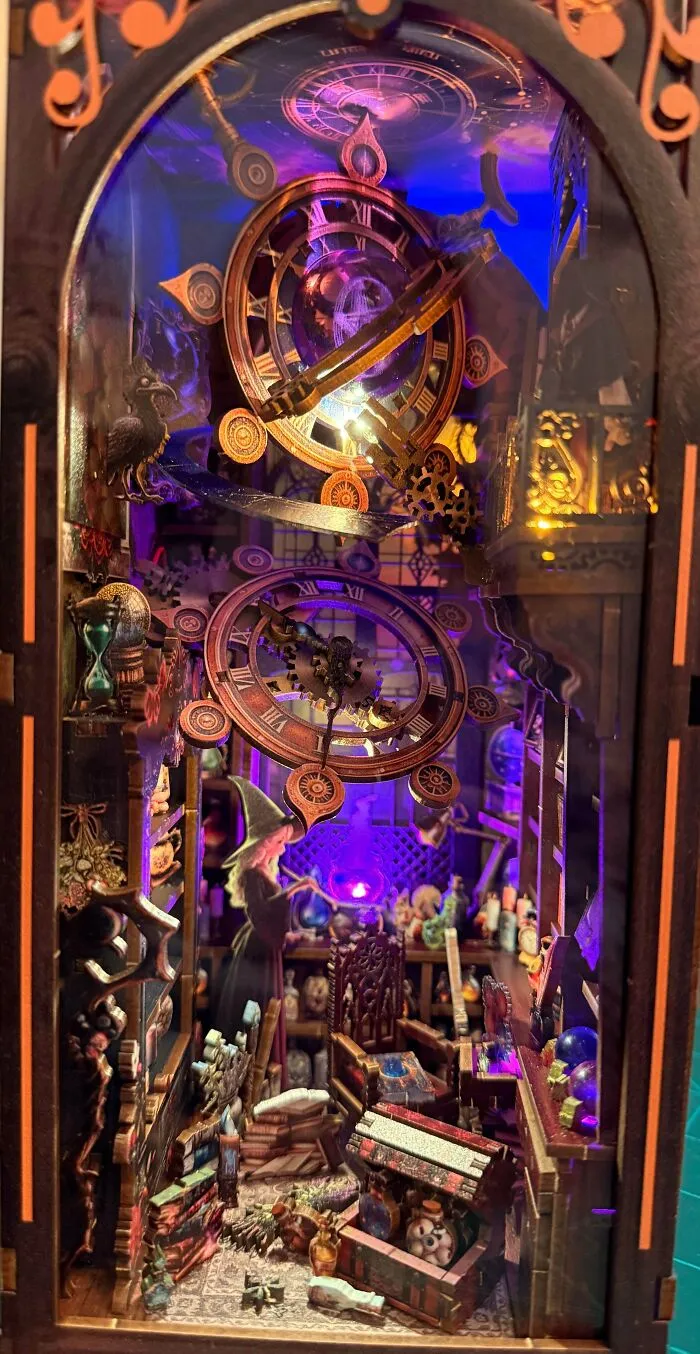 A magical wizard book nook showing a witch casting spells among books and illuminated clock gears.