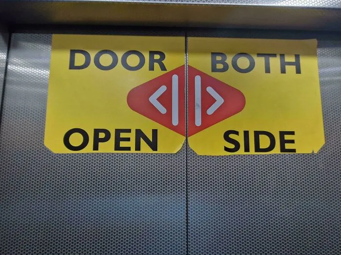 Hilarious badly designed signs on elevator doors reading DOOR BOTH OPEN SIDE with arrows split across the middle