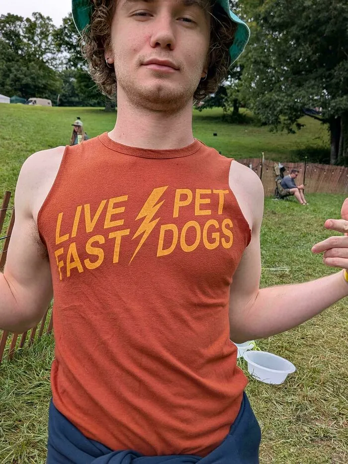 A person wearing a tank top with a badly designed sign layout reading LIVE PET FAST DOGS