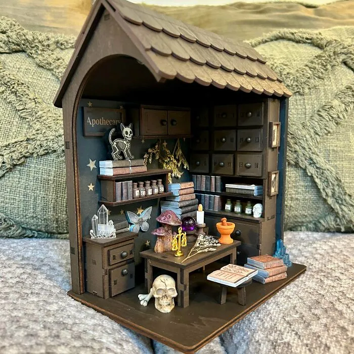 An apothecary shop themed miniature book nooks insert with tiny skulls, potions, and crystals