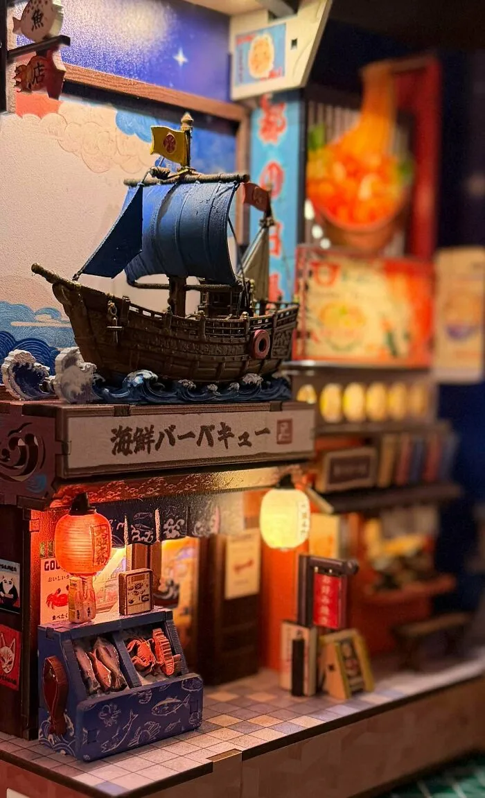 A Japanese street food stall styled miniature book nooks insert with a blue sailboat model