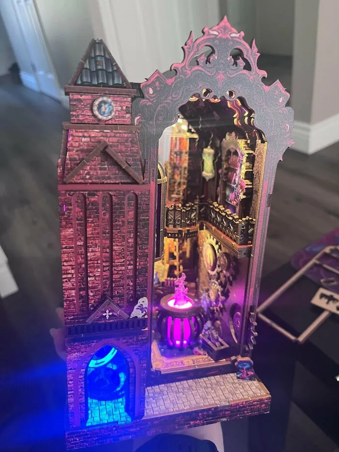 Gothic alchemy lab book nook with a glowing purple cauldron and red brick tower
