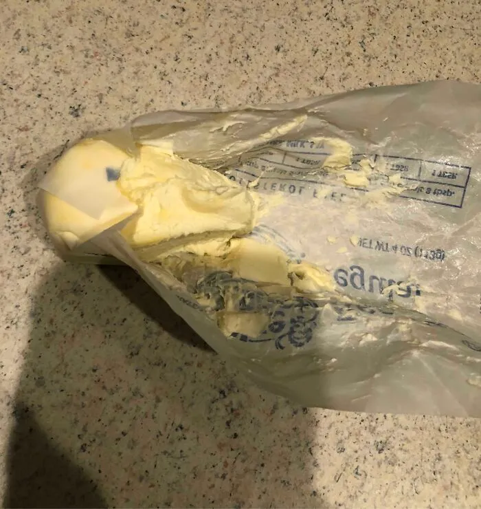 A block of butter messy and torn open in its wrapper, showing unhinged things wives do.
