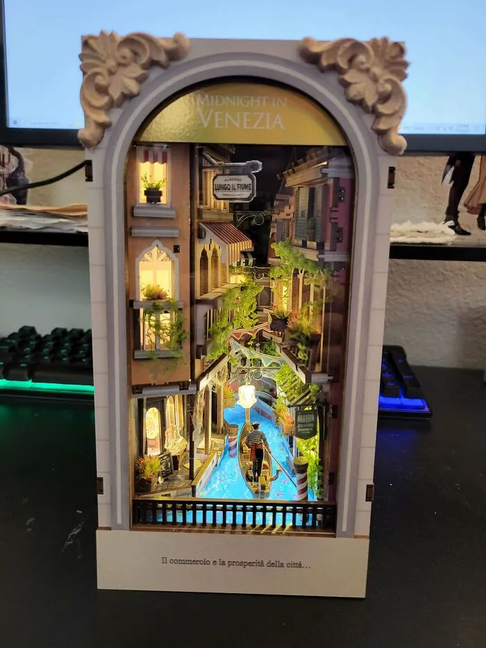 A miniature book nook capturing a Venice canal at night with a gondola and warm lights