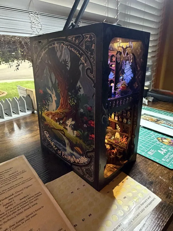 A dark fantasy book nook depicting the Chamber of Exotic Beasts with intricate illustrations and lights.
