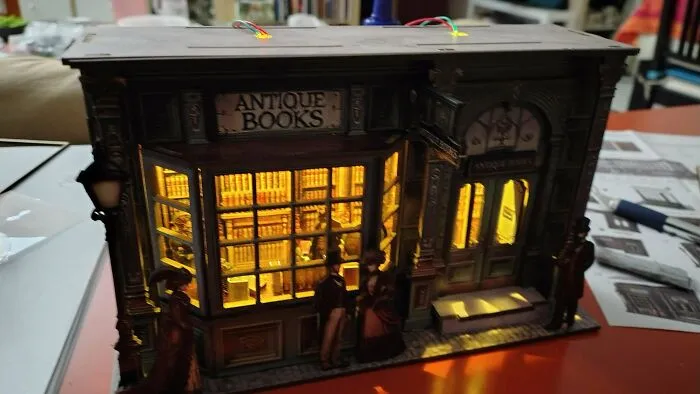 A glowing antique bookshop facade model built as a creative book nook art piece.