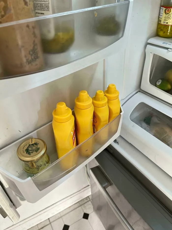 Four mustard bottles lined up in a fridge door, showing funny habits wives have