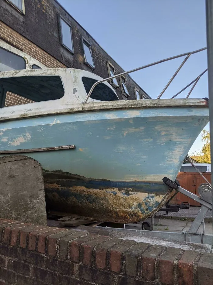 An old blue boat showing how time slowly reshapes its faded and chipped paint job