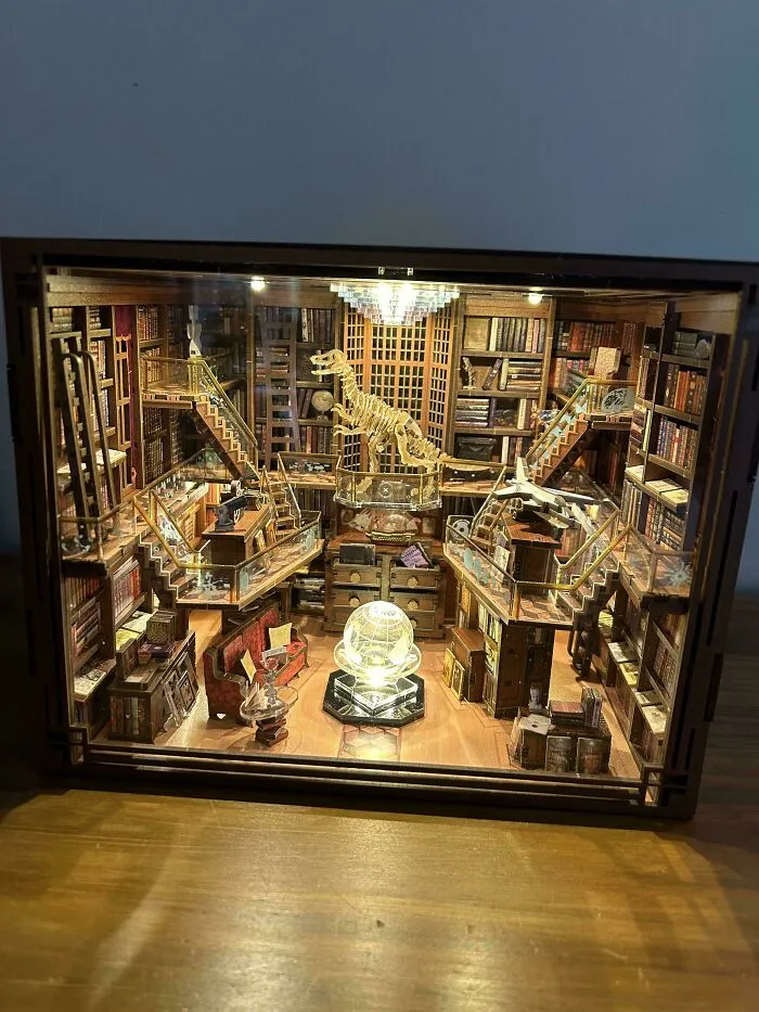 Grand library diorama featuring a dinosaur skeleton in book nooks
