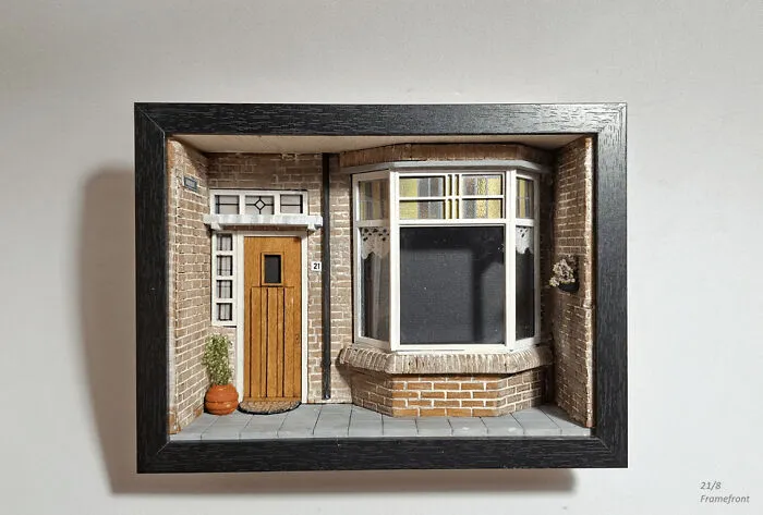 A miniature book nook resembling a brick townhouse facade with a bay window and wooden door