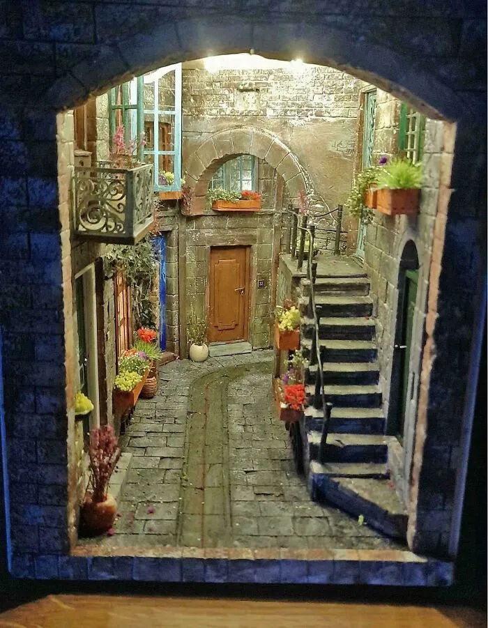 A detailed miniature book nook showing an old European alleyway