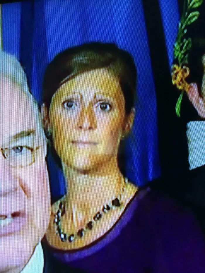 A woman on television with extremely thin, highly arched drawn-on eyebrows, displaying beauty procedures fails