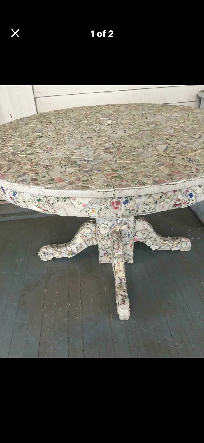 Outdoor table fully covered in broken floral ceramic pieces as a questionable DIY project