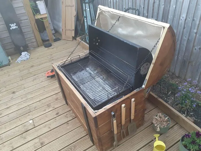 A barbecue grill built inside a wooden treasure chest, showcasing questionable DIY projects.