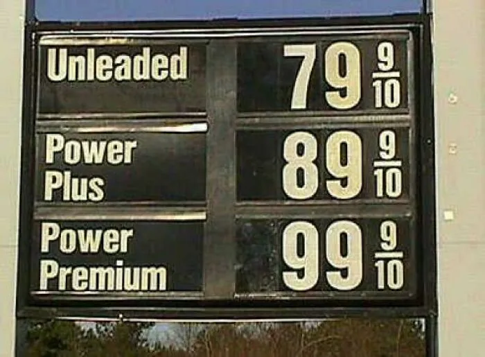 A retro gas station price sign from the 90s displaying cheap unleaded fuel prices