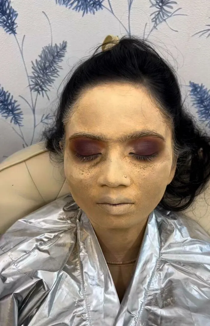 A woman with pale, uneven makeup and dark eyeshadow, showcasing examples of major beauty procedures fails.