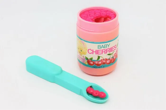 A vintage toy jar of Baby Cherries from the 90s with a spoon