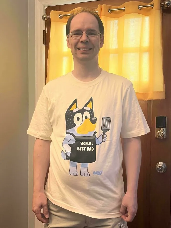 A man wearing a t-shirt featuring Bandit from Bluey, one of many wholesome pics of dads embracing fatherhood