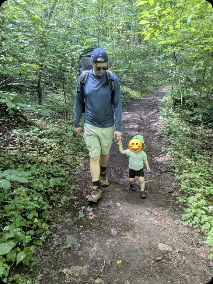 A father hiking with his young child on a trail, capturing wholesome pics of dads enjoying outdoor adventures.