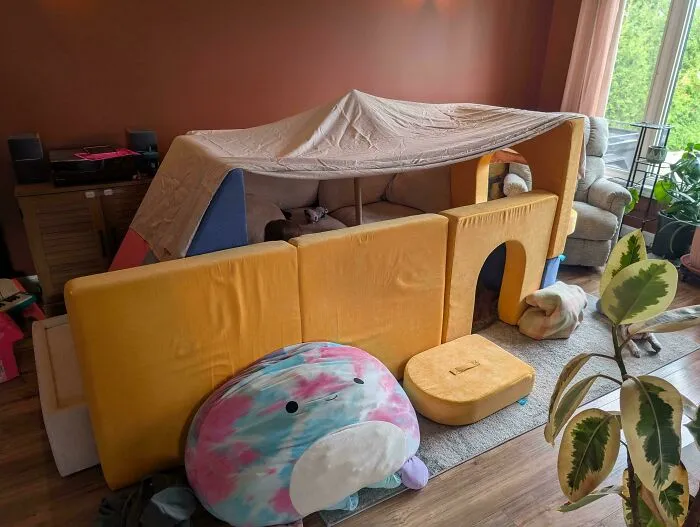 An elaborate indoor blanket fort built in a living room, highlighting creative and wholesome pics of dads.