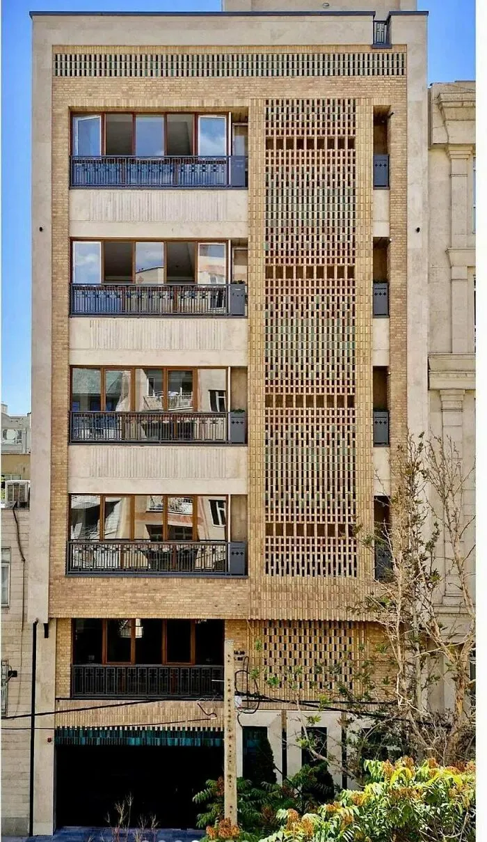 Modern apartment building with an intricate brick facade highlighting unique architectural design.