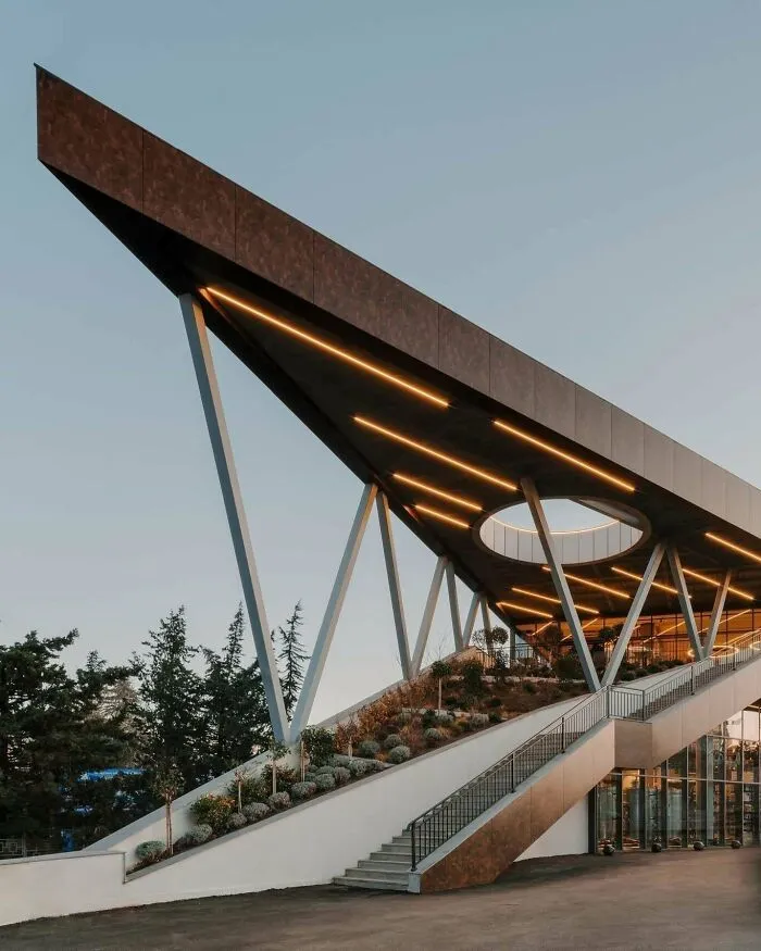 Dramatic sharp geometric roof structure representing contemporary architectural masterpieces at twilight.