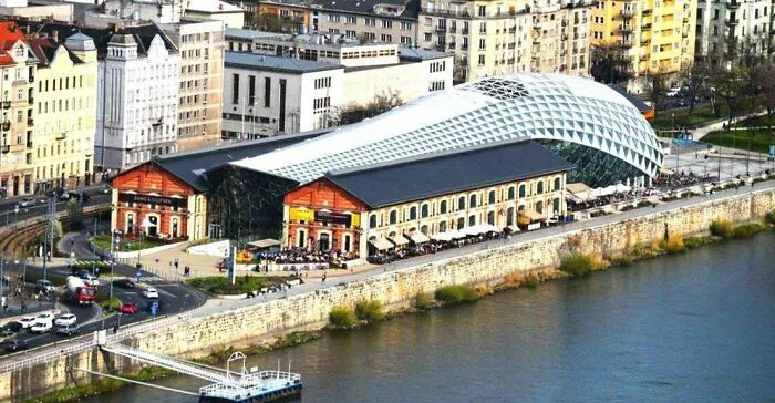 Aerial view of a waterfront glass dome structure showcasing architectural masterpieces along the river.