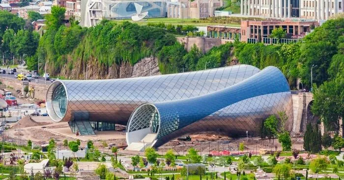 Futuristic metal tube structures in a park, representing unique architectural masterpieces in urban design.