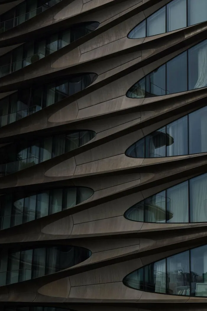 A modern building facade featuring organic flowing curves, an architectural masterpiece in contemporary design.