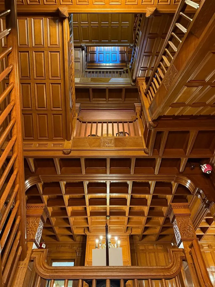 Intricate wooden staircase and coffered ceiling showcasing architectural masterpieces inside a classic building