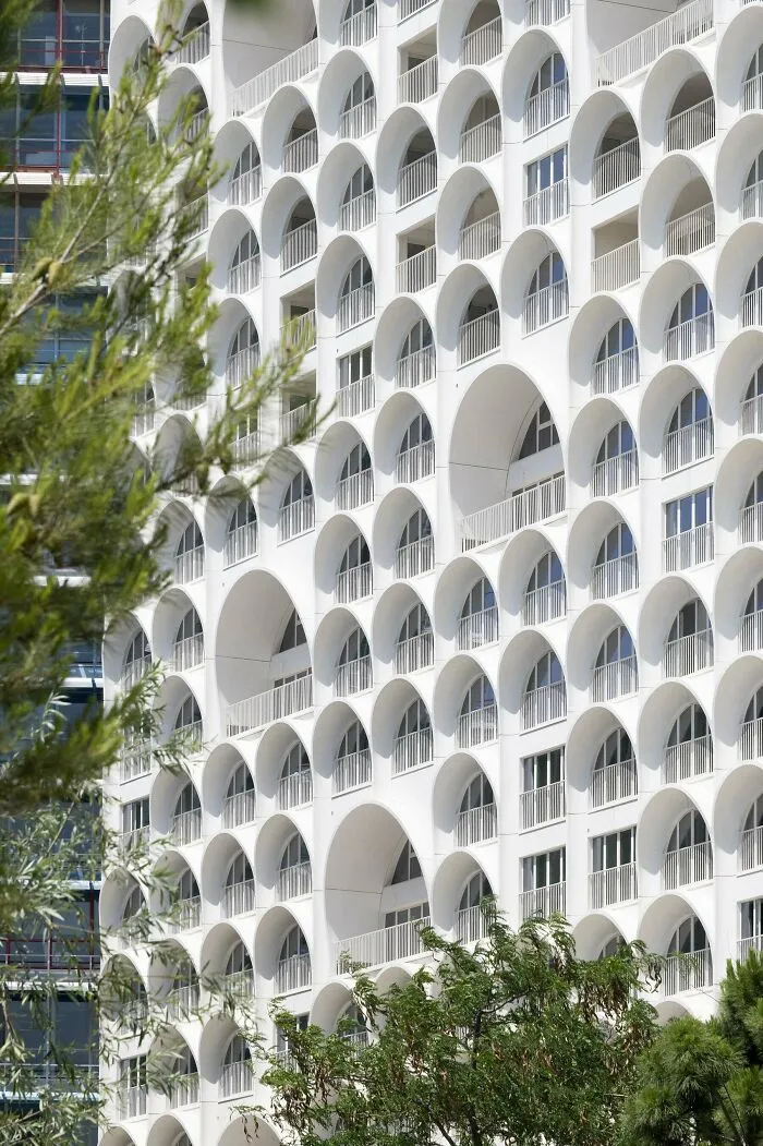 White modern building façade featuring repeating arch windows as stunning architectural masterpieces.