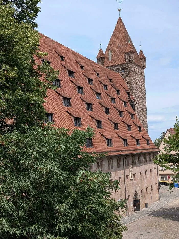 Historic stone building with a steeply pitched tiled roof showcasing stunning architectural masterpieces in Europe.