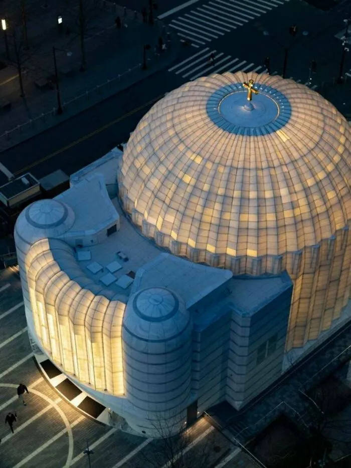 Aerial view of a glowing domed church, highlighting modern architectural masterpieces in urban planning.