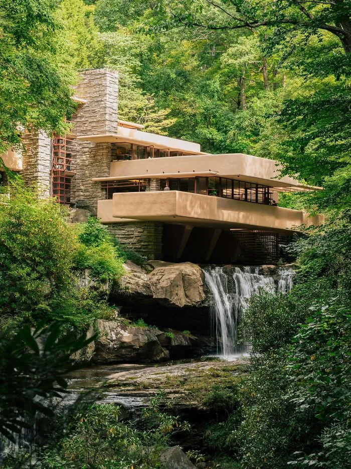 Fallingwater house over a waterfall, an iconic architectural masterpiece nestled in lush forest surroundings.