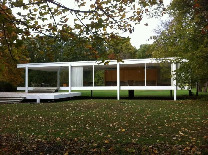 Modern minimalist glass house nestled in trees, one of many iconic architectural masterpieces