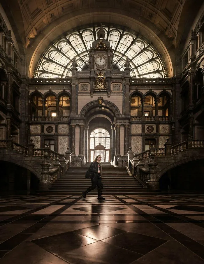 Grand hall with high arched windows and ornate stairs, highlighted among architectural masterpieces