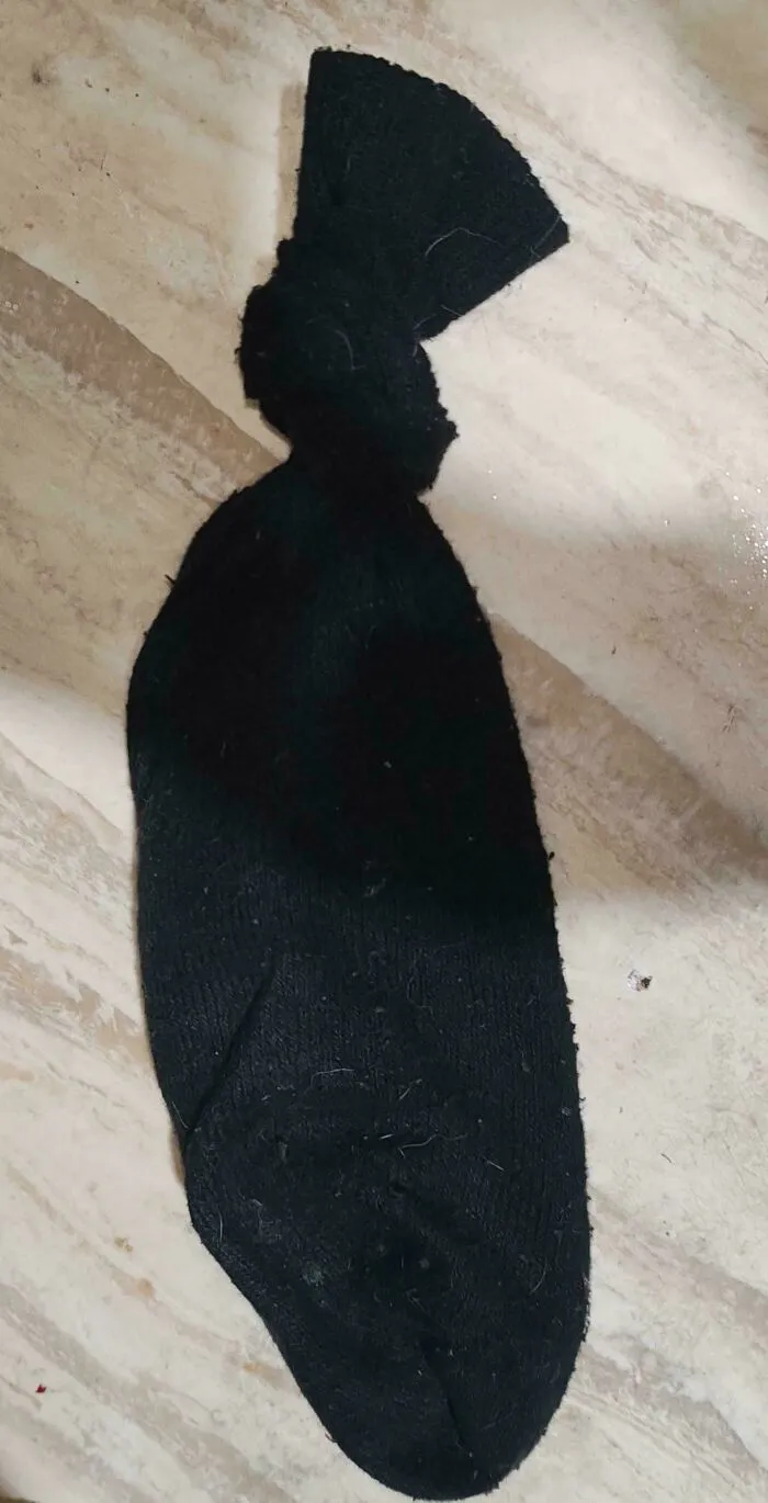 A black sock tied in a knot, illustrating simple frugal tips for reusing household items.