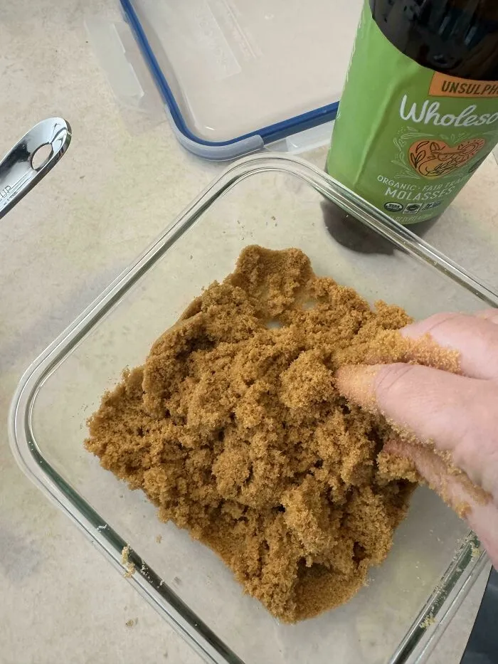 Mixing brown sugar and molasses in a container as part of helpful frugal tips for homemade ingredients.
