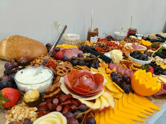 A lavish grazing table with meats and cheeses, showing creative frugal tips for home entertaining.