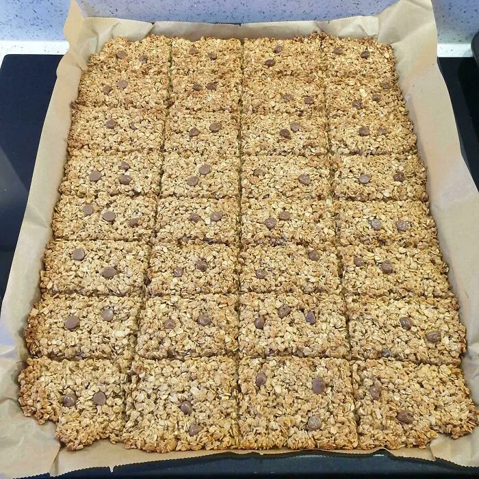 A large baking sheet filled with freshly baked homemade granola bars representing smart frugal tips.