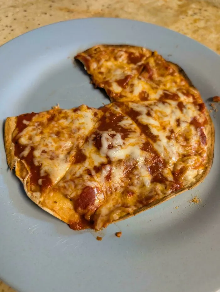 A homemade tortilla pizza on a plate representing frugal tips for budget meal preparation.