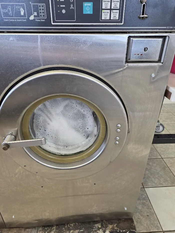 Commercial washing machine in action showing frugal tips for saving on laundry.