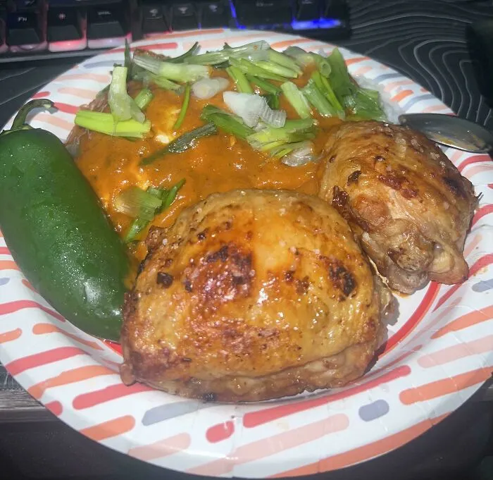 A home-cooked meal featuring chicken and vegetables served on a paper plate, demonstrating frugal tips.
