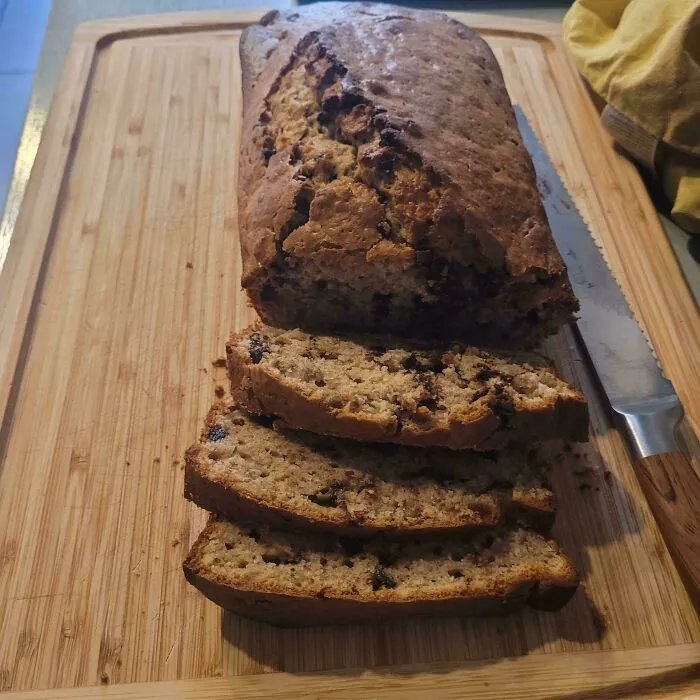 Freshly sliced homemade banana bread on a board highlighting frugal tips.