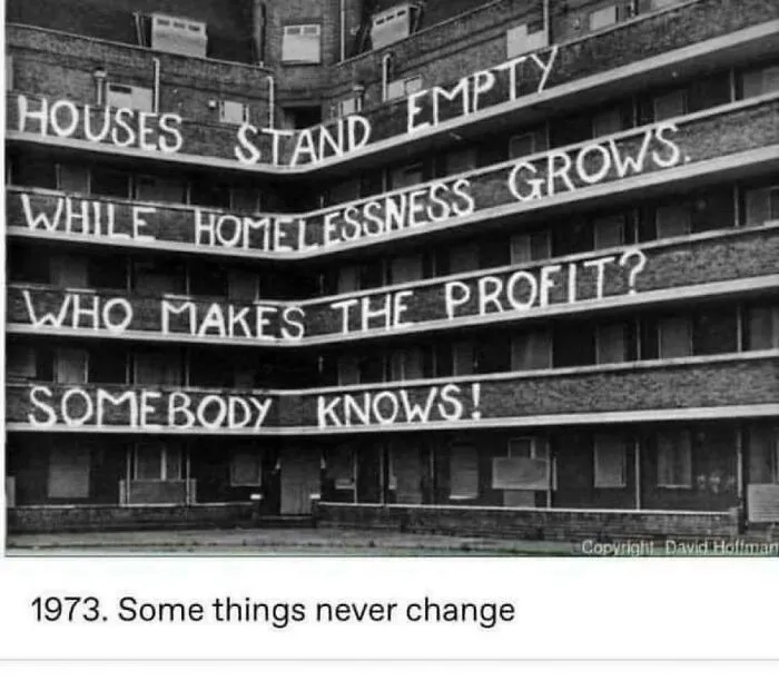 An old building with protest banners about empty houses, illustrating problems with terrible landlords.